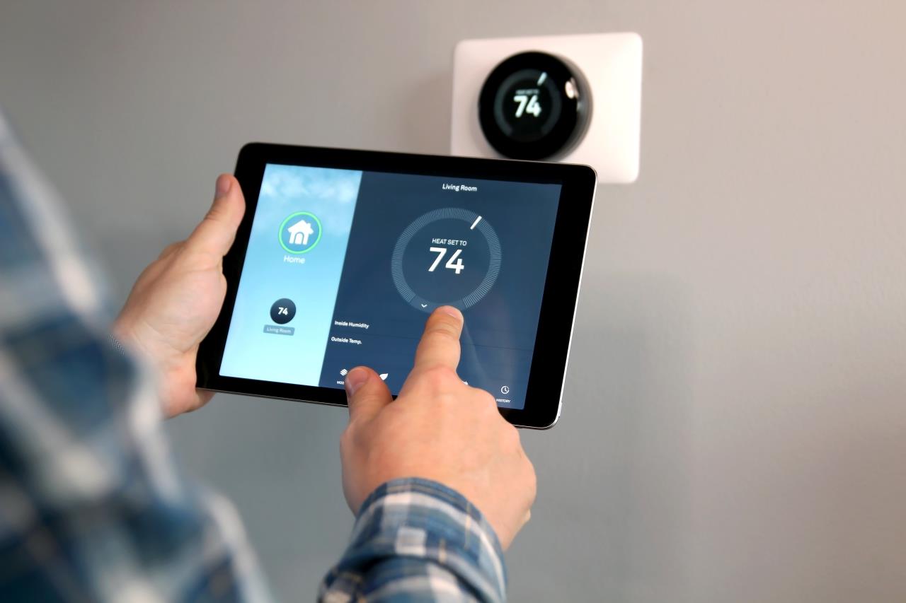 Man with tablet and smart thermostat