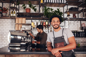 Male coffee shop owner standing at the counter